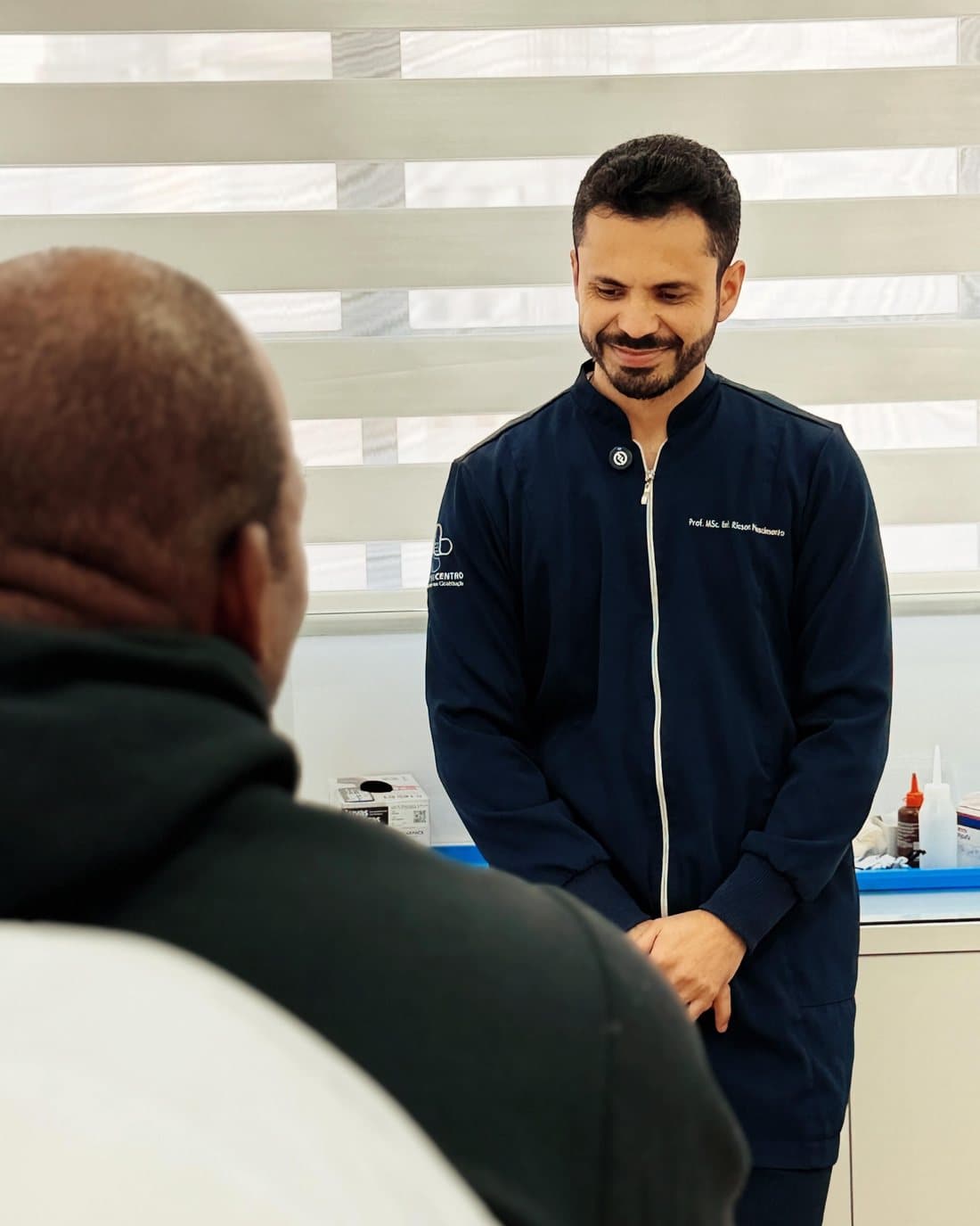 Profissional da Cicatricentro conversando com um paciente durante o atendimento no consultório